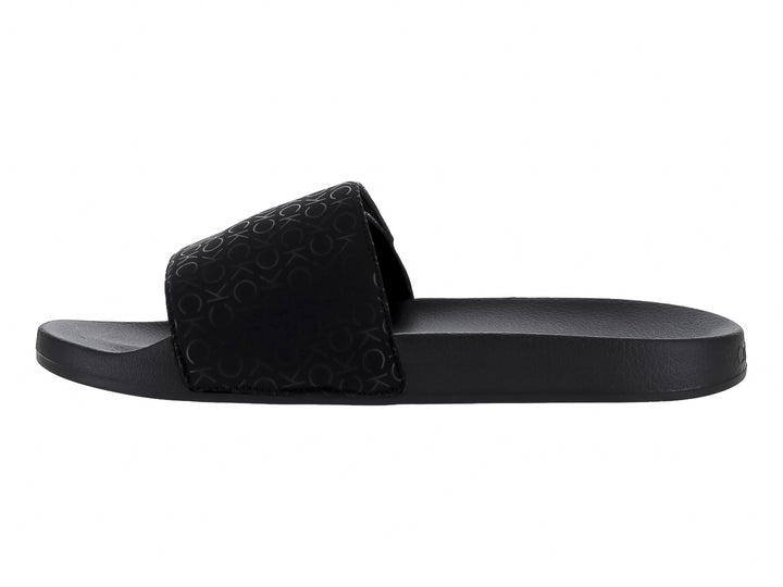 Sandalias slide negras de Calvin Klein con logotipo grabado en la banda superior y suela mate.