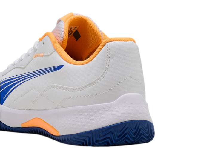 Tenis PUMA Nova Smash en color blanco con detalles gráficos en azul y naranja y suela verde.
