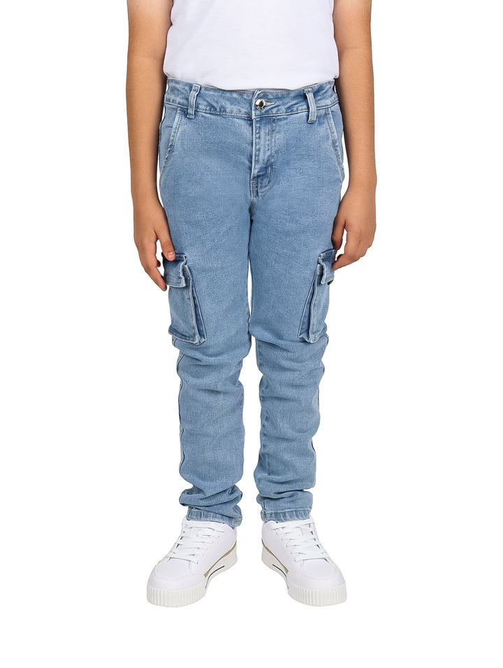Pantalones vaqueros tipo cargo en color azul claro para niño, con bolsillos laterales y corte ajustado.