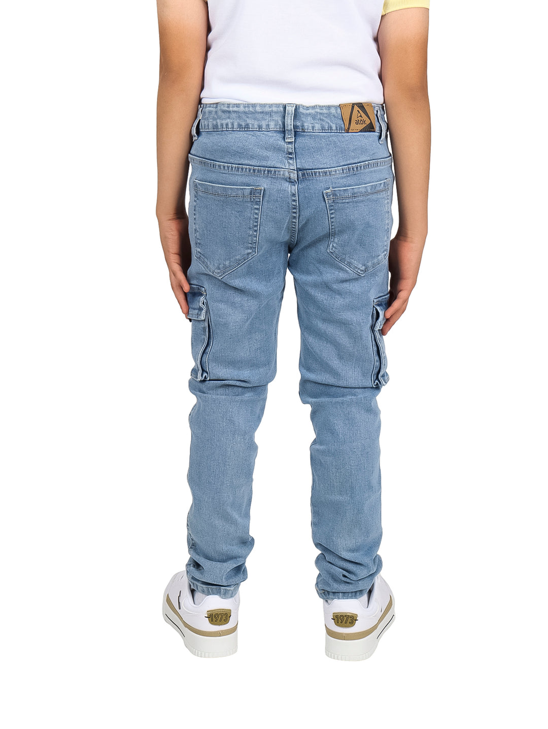 Pantalones vaqueros tipo cargo en color azul claro para niño, con bolsillos laterales y corte ajustado.