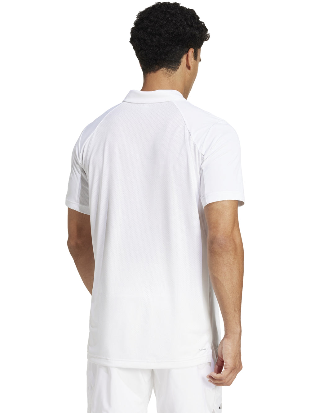 Hombre vistiendo una playera polo deportiva Adidas de color blanco con logo en el pecho.