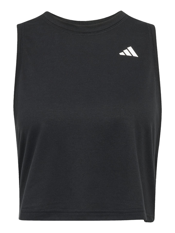 Mujer vistiendo un top deportivo negro sin mangas de corte boxy y shorts negros de la marca Adidas.