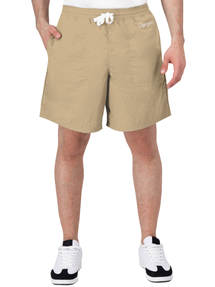 Hombre vistiendo pantalones cortos de surf color khaki de la marca Champion con cordón blanco en la cintura.