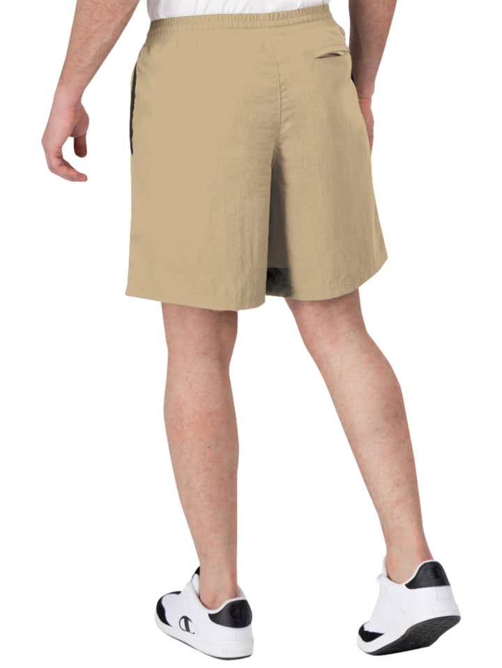 Hombre vistiendo pantalones cortos de surf color khaki de la marca Champion con cordón blanco en la cintura.