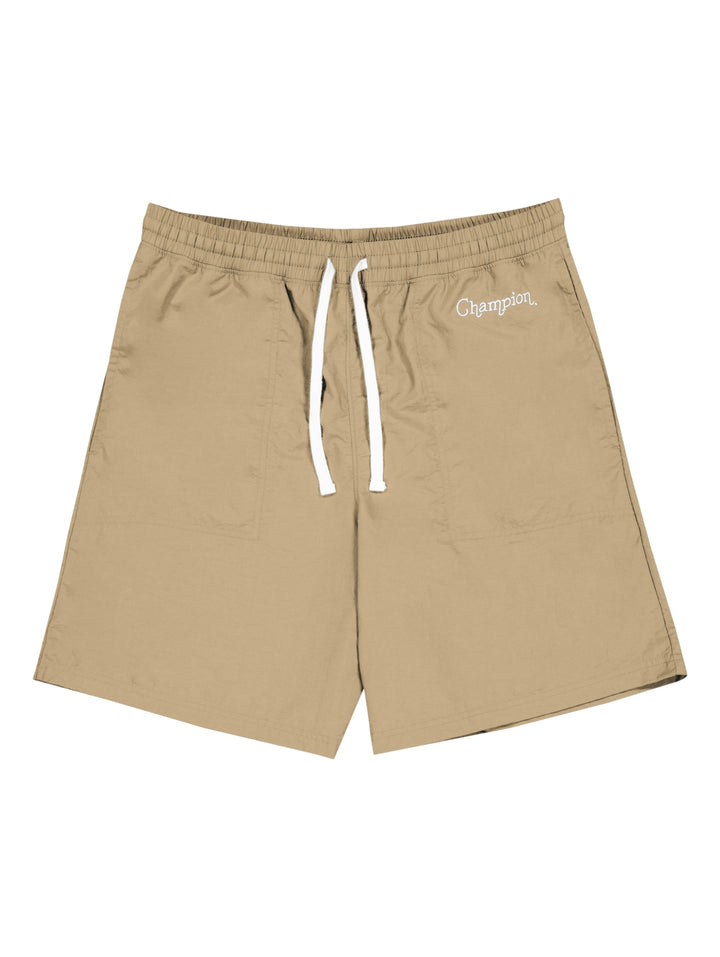 Hombre vistiendo pantalones cortos de surf color khaki de la marca Champion con cordón blanco en la cintura.