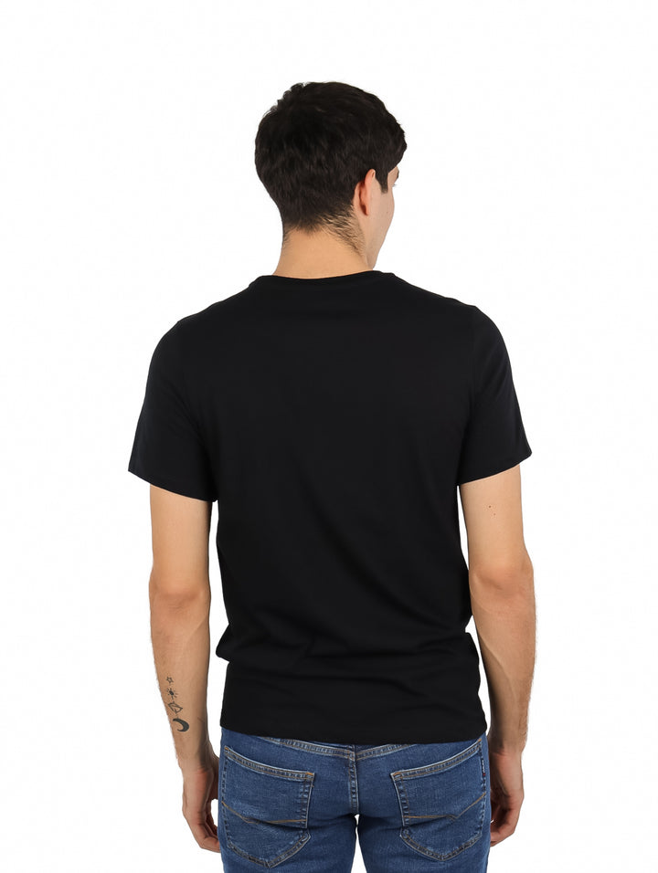 Hombre vistiendo playera negra de manga corta con rayas horizontales azul y roja y logo K-Swiss en el pecho.