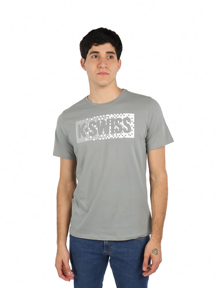Hombre vistiendo playera gris de manga corta con logotipo de K-SWISS en el pecho.