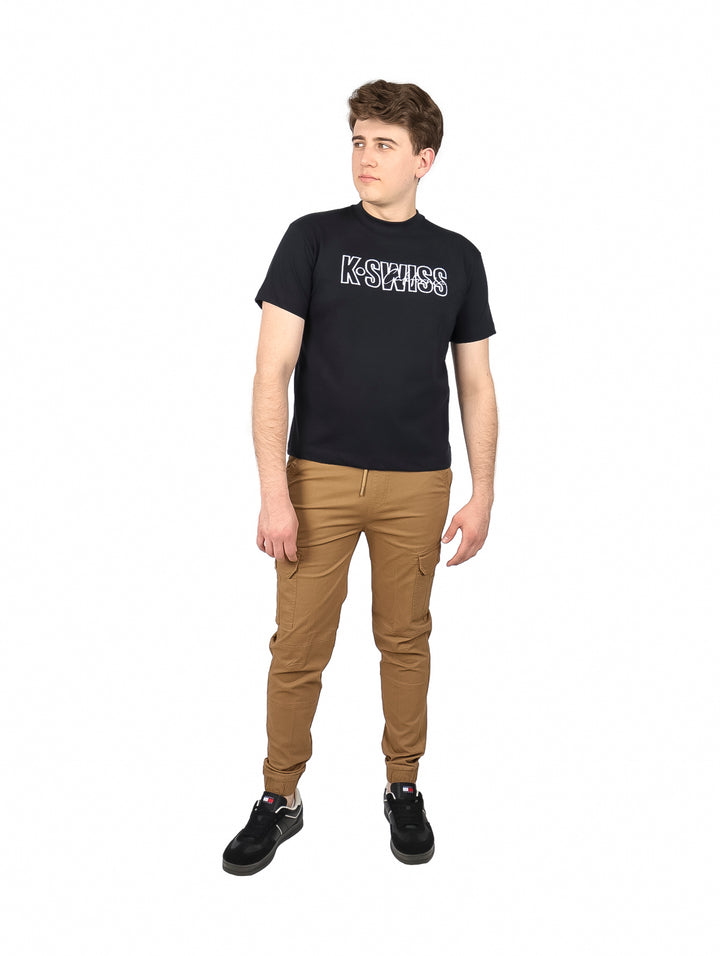 Hombre vistiendo playera negra de manga corta con logo de K-SWISS en el pecho.