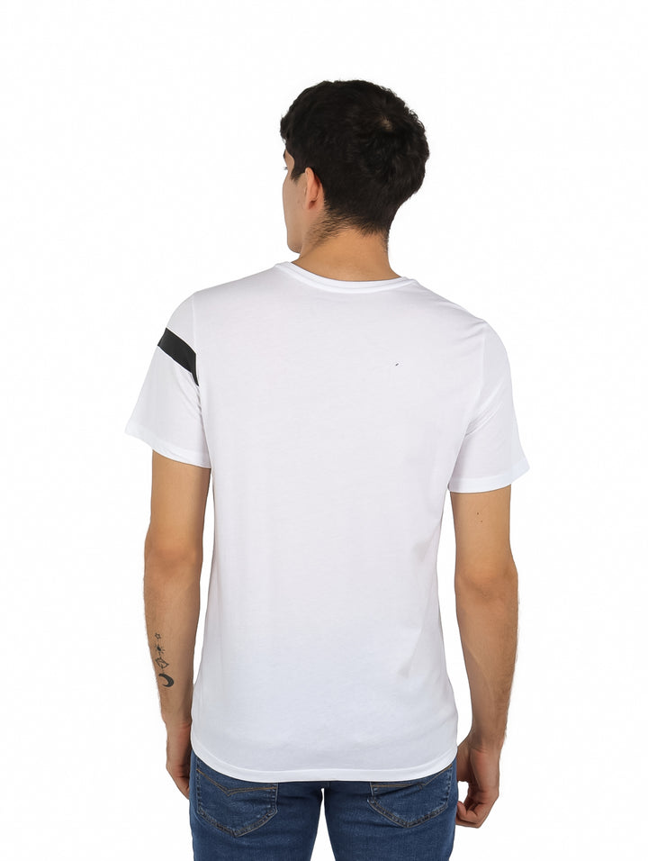 Hombre vistiendo playera blanca de manga corta con franja negra horizontal en el pecho y logo de K-SWISS.