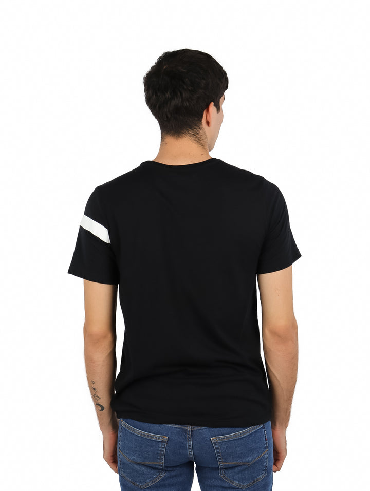 Hombre vistiendo playera negra de manga corta con una línea blanca horizontal en el pecho y logo de K-Swiss.