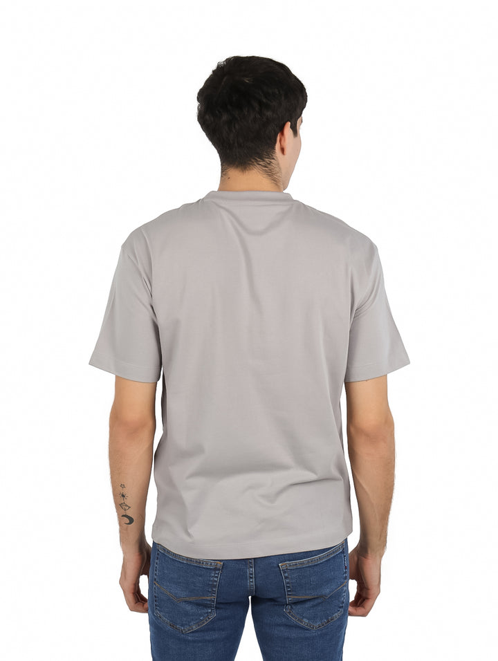 Hombre vistiendo playera gris de manga corta K-Swiss con estampado lateral y cuello redondo.