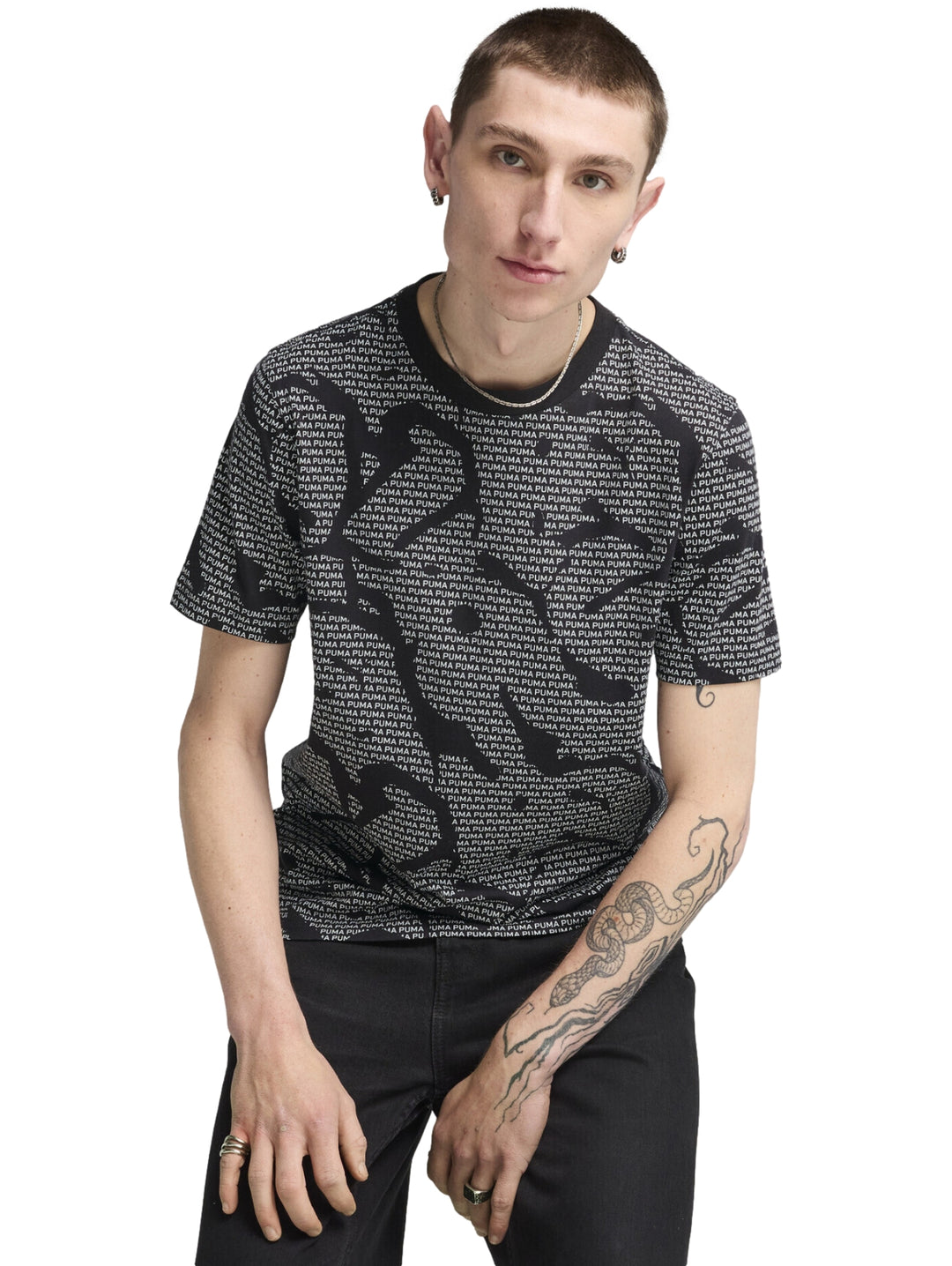 Camiseta negra de manga corta con estampado repetitivo de la marca PUMA en color blanco.