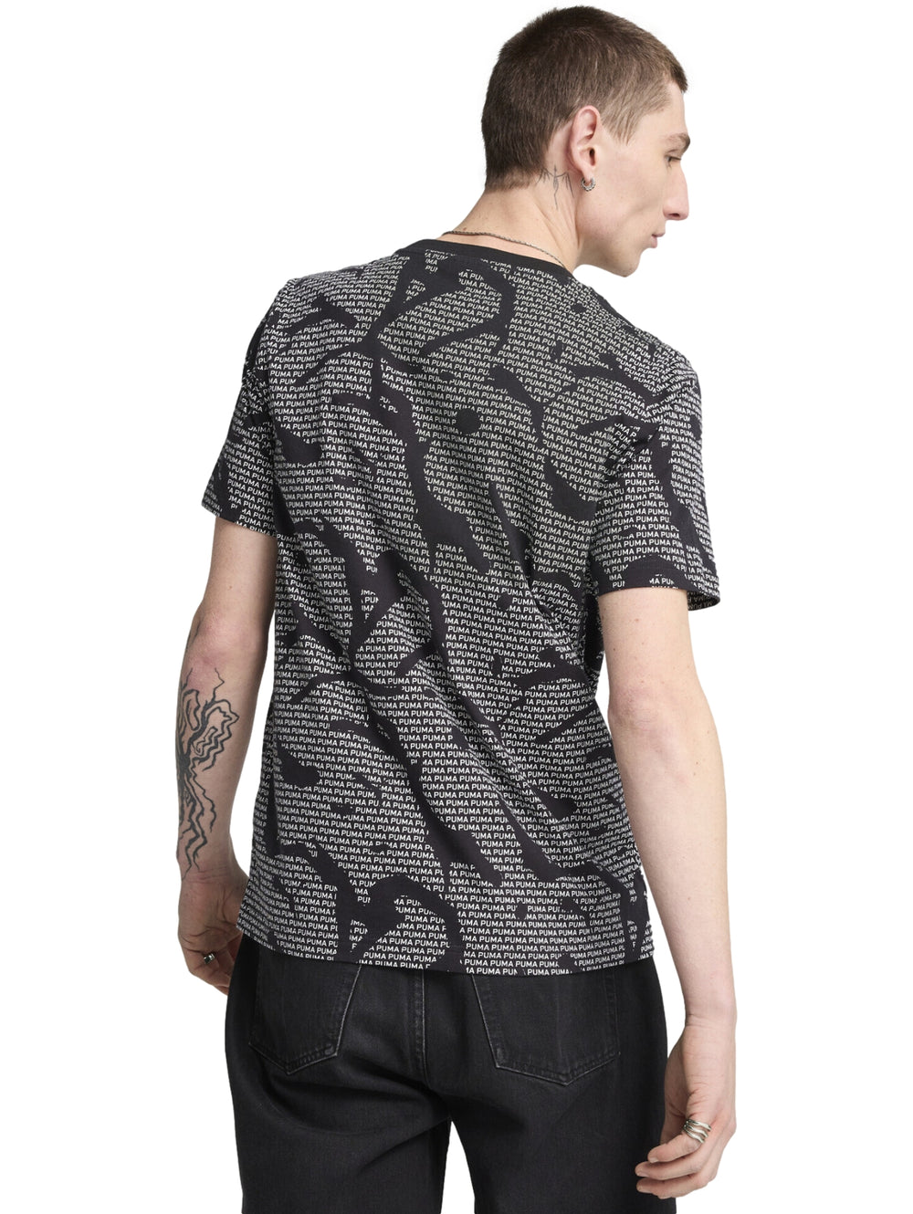 Camiseta negra de manga corta con estampado repetitivo de la marca PUMA en color blanco.