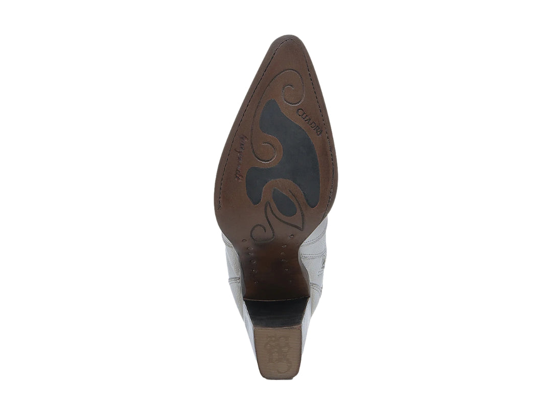 Bota vaquera de cuero blanco con tacón marrón y detalles ornamentales bordados.