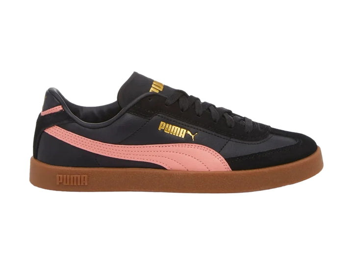 Tenis PUMA negros con franja rosa lateral y suela de goma marrón.