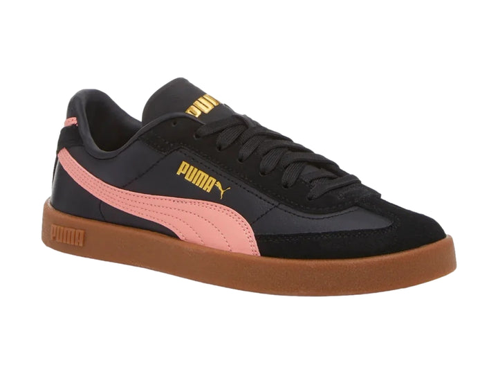 Tenis PUMA negros con franja rosa lateral y suela de goma marrón.