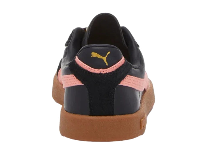 Tenis PUMA negros con franja rosa lateral y suela de goma marrón.