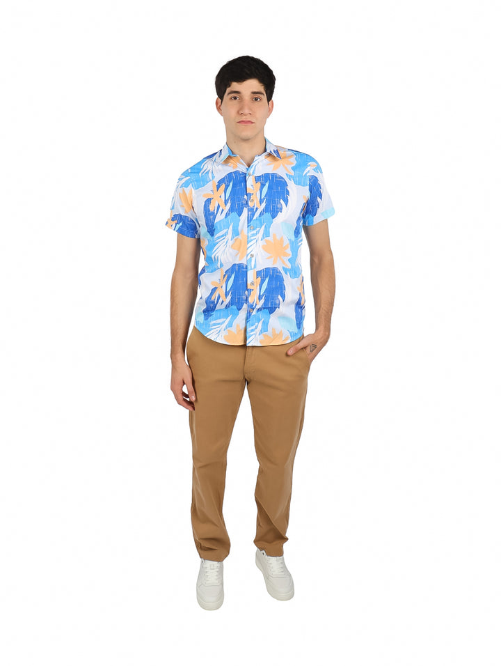 Hombre vistiendo camisa de manga corta color azul cielo con estampado tropical en tonos naranja.