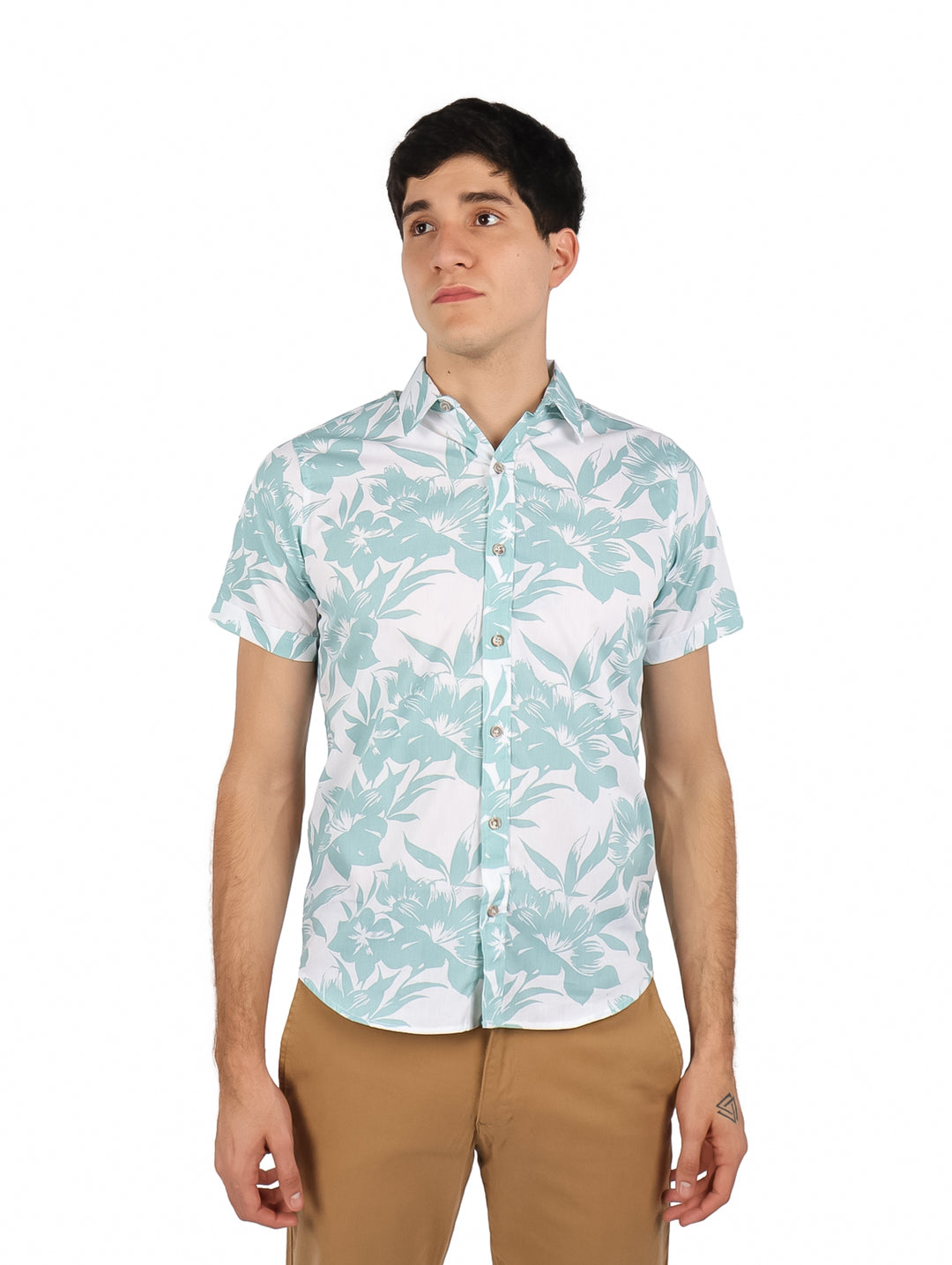 Hombre vistiendo camisa de manga corta blanca con estampado floral verde y pantalones color café.