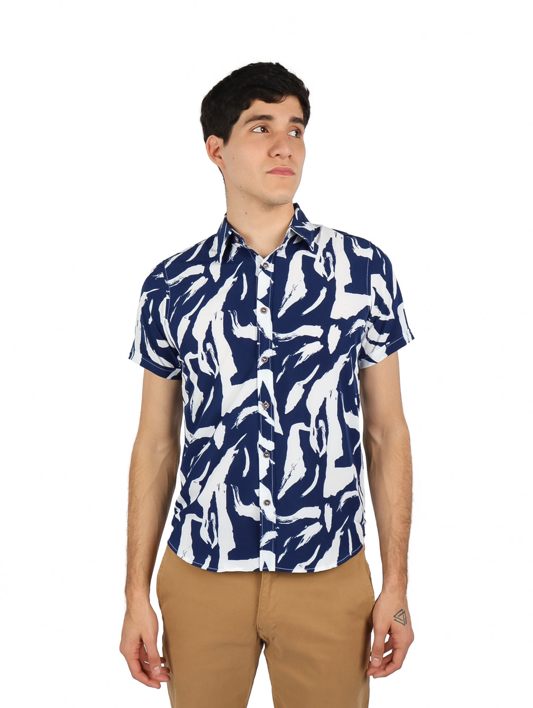 Hombre vistiendo camisa de manga corta con estampado abstracto en colores azul marino y blanco.