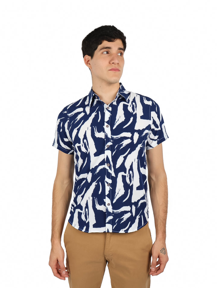 Hombre vistiendo camisa de manga corta con estampado abstracto en colores azul marino y blanco.
