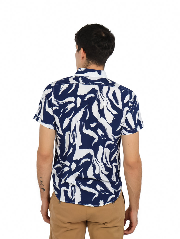 Hombre vistiendo camisa de manga corta con estampado abstracto en colores azul marino y blanco.
