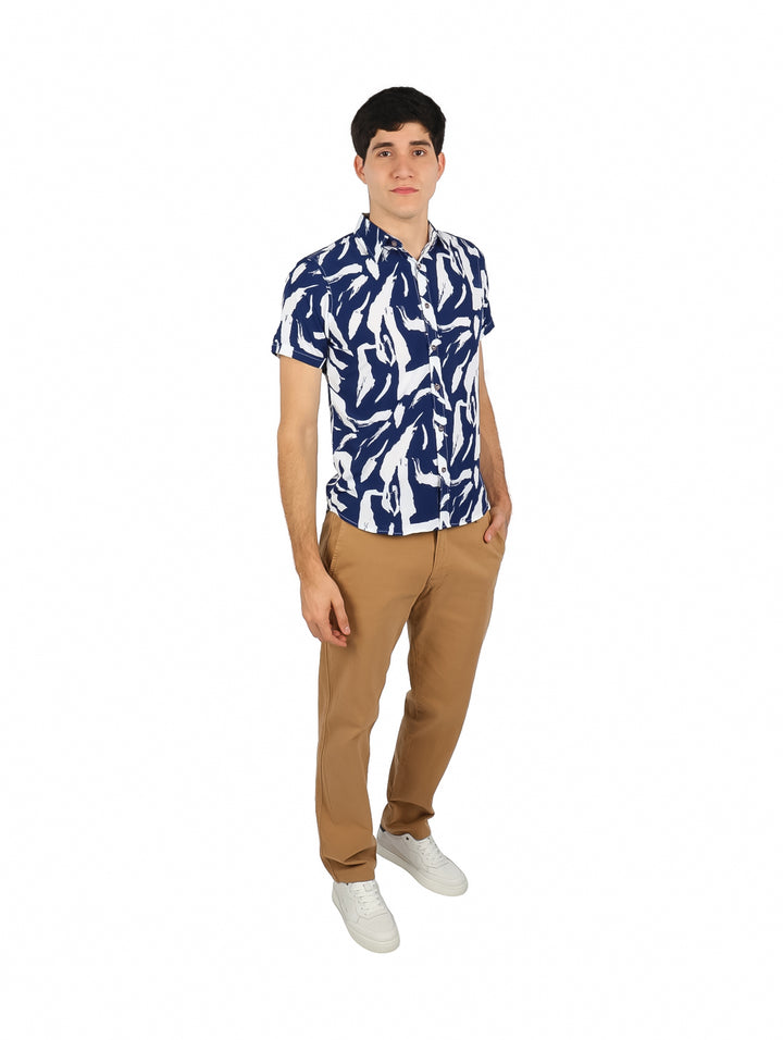 Hombre vistiendo camisa de manga corta con estampado abstracto en colores azul marino y blanco.