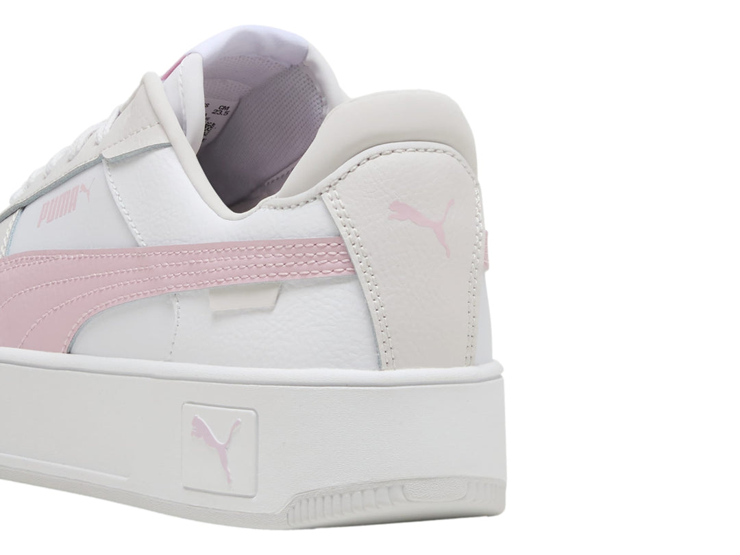 Tenis PUMA Carina Street blancos con detalle en rosa y suela de plataforma blanca.