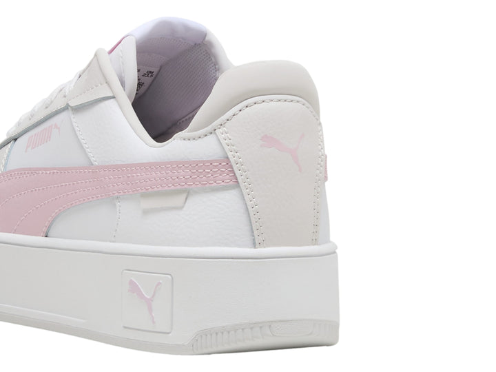 Tenis PUMA Carina Street blancos con detalle en rosa y suela de plataforma blanca.
