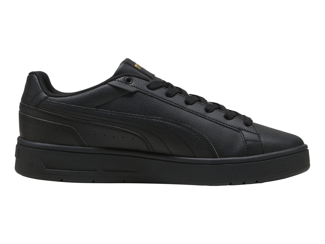 Tenis PUMA Court Classico color negro con suela plana y textura de cuero.