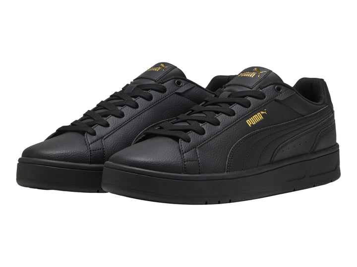Tenis PUMA Court Classico color negro con suela plana y textura de cuero.