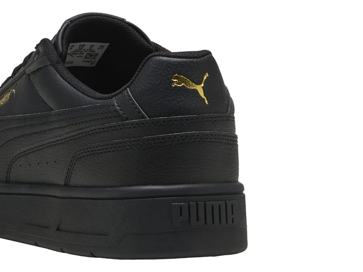 Tenis PUMA Court Classico color negro con suela plana y textura de cuero.