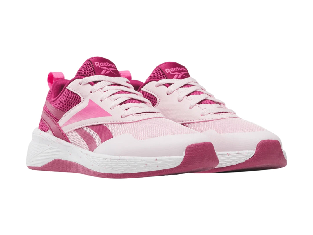 Tenis deportivos Reebok color rosa y blanco con suela blanca y detalles en rosa intenso.