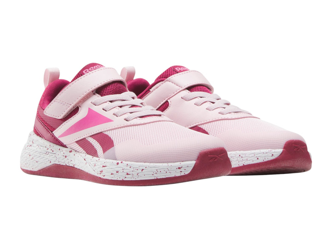 Tenis deportivos Reebok color rosa con suela blanca moteada y correa superior para Niña.