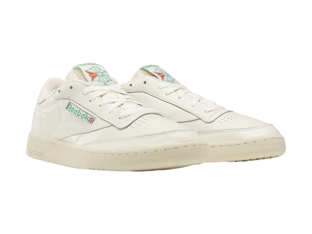 Tenis blancos Reebok Club C 85 Vintage con suela color crema y detalles coloridos.
