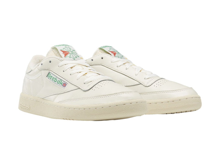 Tenis blancos Reebok Club C 85 Vintage con suela color crema y detalles coloridos.