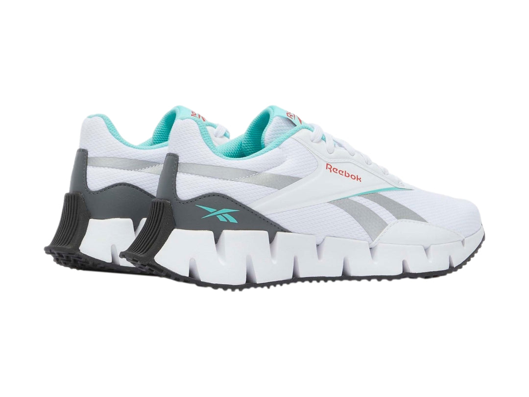 Tenis deportivos Reebok Zig Dynamica en color blanco con detalles en gris y turquesa.