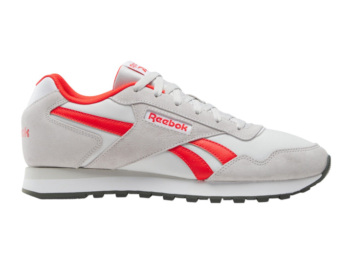 Tenis deportivos Reebok en color blanco con detalles en rojo y suela blanca.
