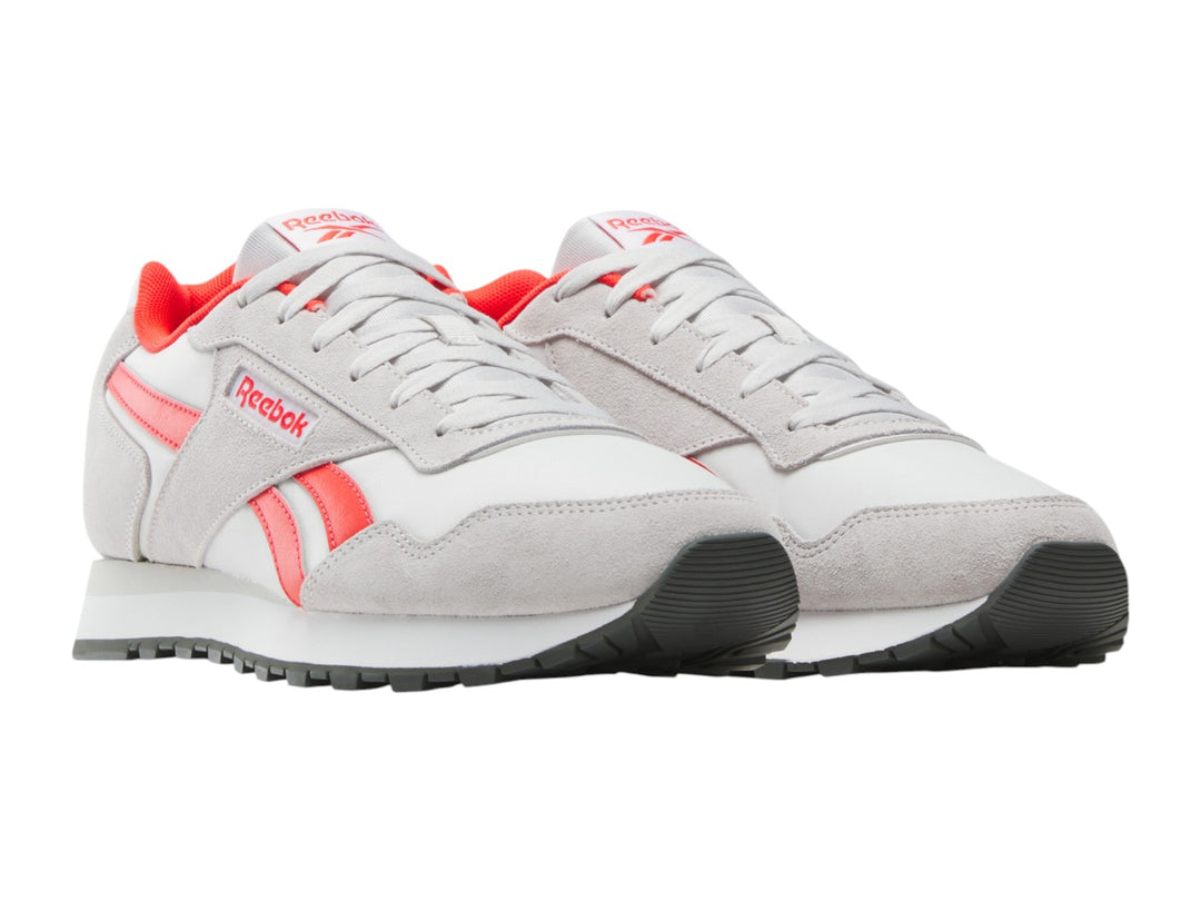 Tenis deportivos Reebok en color blanco con detalles en rojo y suela blanca.