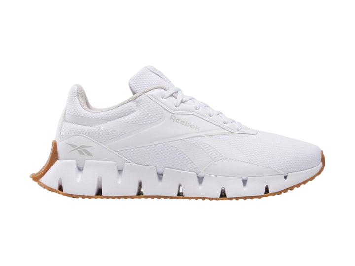 Tenis deportivos Reebok Zig Dynamica en color blanco con suela blanca y base café.