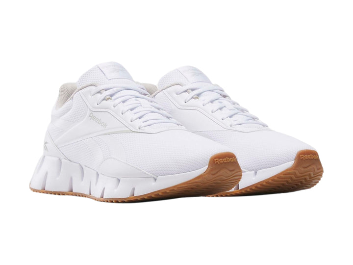 Tenis deportivos Reebok Zig Dynamica en color blanco con suela blanca y base café.