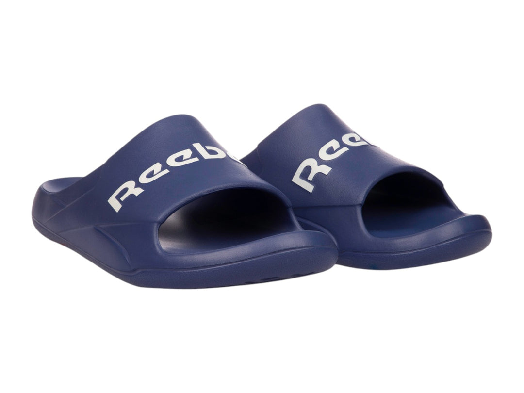 Sandalia deslizable Reebok de color azul con logotipo blanco en la parte superior.