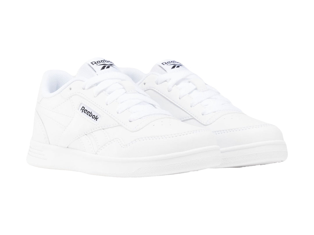 Tenis deportivos Reebok color blanco para niños con suela plana y agujetas.
