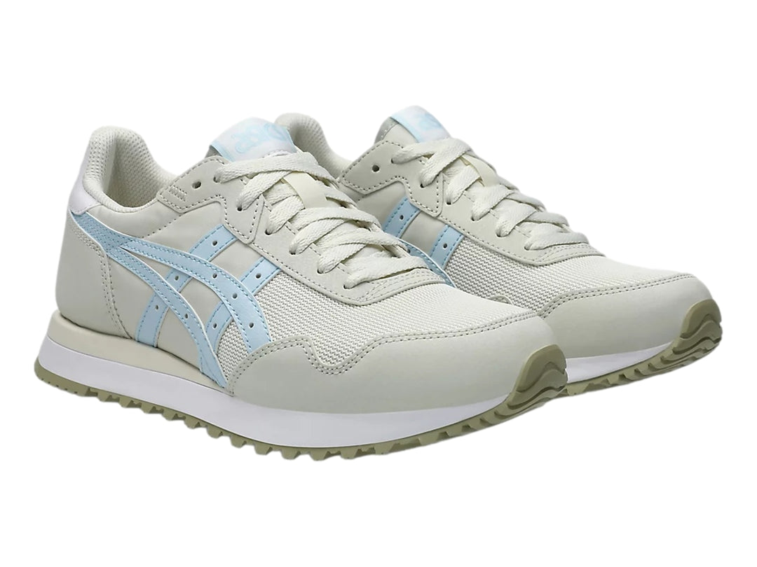 Tenis ASICS Tiger Runner color crema con detalles en azul claro y suela blanca.