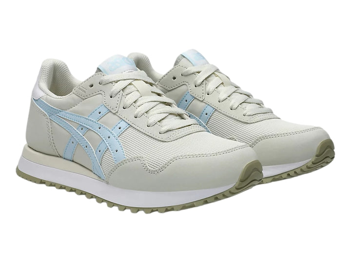 Tenis ASICS Tiger Runner color crema con detalles en azul claro y suela blanca.