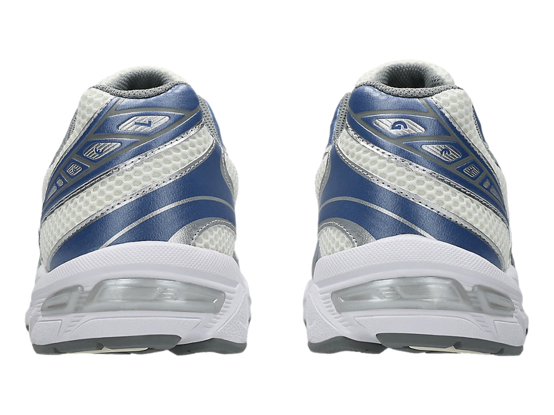 Tenis deportivos ASICS GEL-1130 en color blanco con detalles en azul y plata.