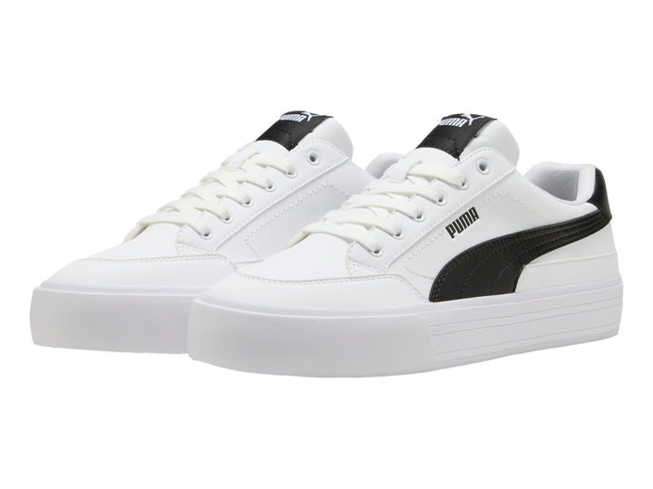 Tenis PUMA blancos de corte bajo con detalle negro en el talón y suela blanca plana.