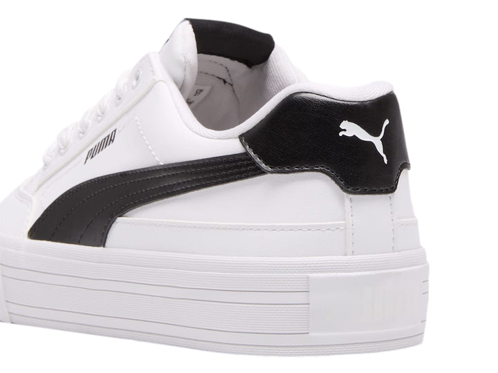 Tenis PUMA blancos de corte bajo con detalle negro en el talón y suela blanca plana.