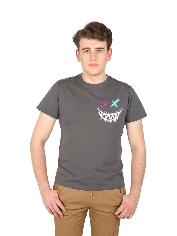 Hombre vistiendo una playera gris de manga corta con un estampado gráfico en el pecho.