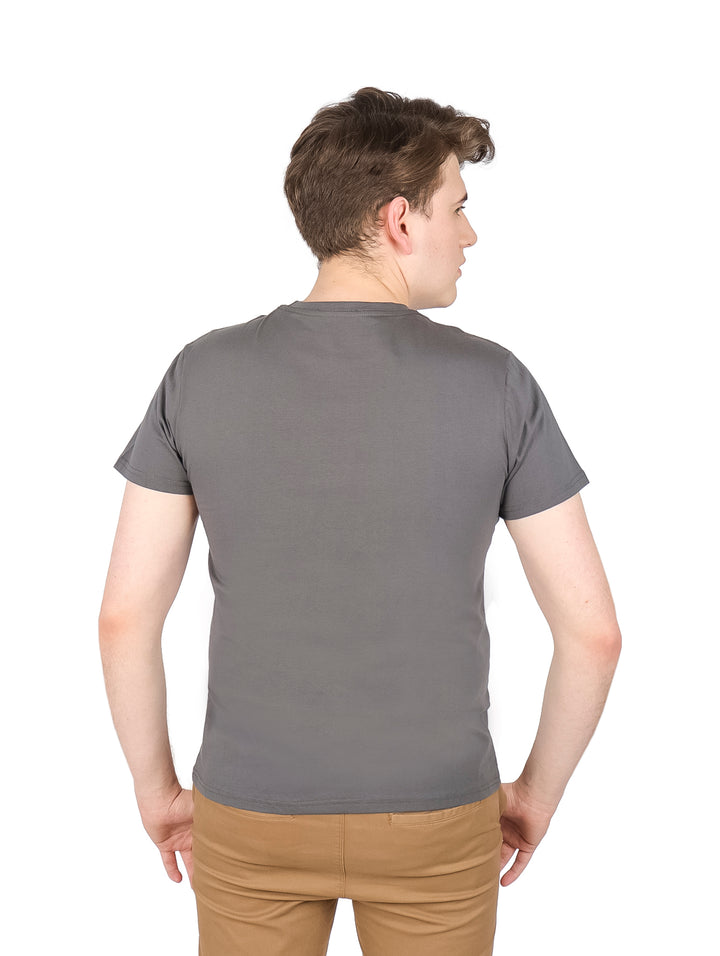 Hombre vistiendo una playera gris de manga corta con un estampado gráfico en el pecho.